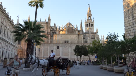 Static-shot-of-Seville-Cathedral-and-tourists-during-sunset,-Spain