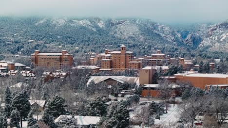 Drone-ascends-snow-covered-evergreen-trees-to-establish-legendary-destination-resort-in-Colorado