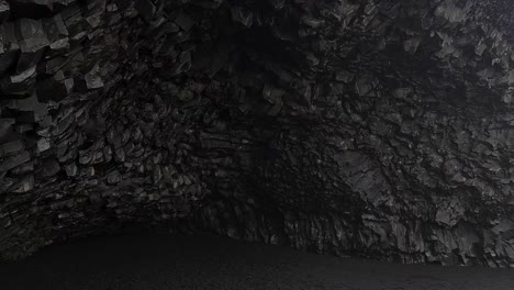 Basalt-Rocks-and-Cave-on-Black-Sand-Beach,-Iceland-on-Cold-Rainy-Day