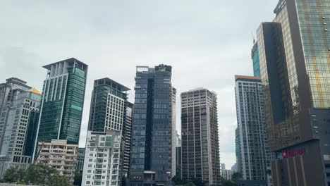 Vista-De-Los-Edificios-Altos-De-La-Ciudad-De-Kuala-Lumpur,-Malasia,-Desde-La-Ventana-Del-Taxi-En-Movimiento