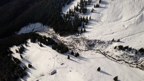 Snow-covered-Lespezi-sheepfold-in-Fagaras-Mountains-with-a-clear-sky,-aerial-view