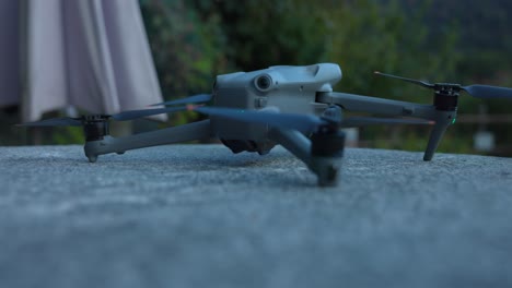 Close-up-of-DJI-Air-3-drone-turning-on-and-taking-off-from-flat-surface