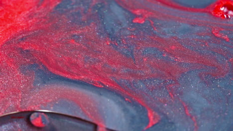 Tinta-Roja-Abstracta-Arremolinándose-Con-Gracia-En-Agua-Azul,-Creando-Una-Fascinante-Mezcla-De-Colores