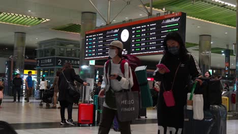 Travellers-with-suitcases-navigate-through-Taoyuan-High-Speed-Rail-Station's-arrival-and-departure-hall,-connecting-effortlessly-to-airport-networks,-capturing-the-essence-of-Taiwan-tourism