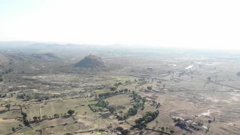 Aerial-rotating-shot-of-barren-arid-land-with-asphalt-road-in-Huntergunj,-Jharkhand,-India