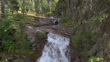 Virginia-Creek-Waterfall-running-into-Virginia-Creek-in-Glacier-National-Park,-tilt-up