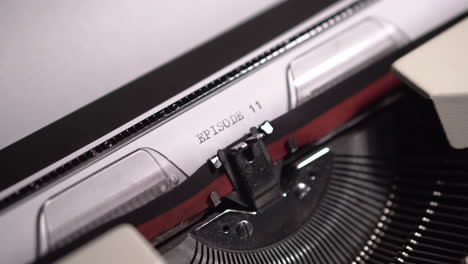 Episode-11-Typing-on-White-Paper,-Vintage-Typewriter,-Writing-Script,-Close-Up