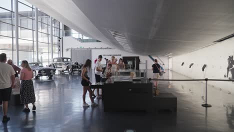 Wide-shot-of-hall-of-tourists-with-miniature-airship-and-cars-at-Zeppelin-Museum