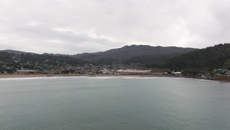 distant-drone-shot-flying-in-towards-Pacifica,-California-on-an-overcast-day