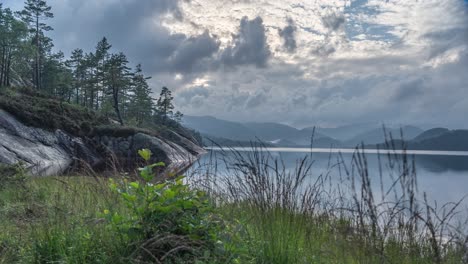 Stürmische-Wolken-Im-Gegenlicht-Der-Sonne-Ziehen-Schnell-über-Den-Stillen-See-Und-Den-Kiefernwald