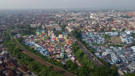 Controversial-slum-tourism-in-the-downtown-of-the-second-biggest-city-of-East-Java,-Malang,-Indonesia,-is-situated-side-by-side-with-the-railway-track-and-bustling-traffic-amidst-an-overpopulated-area