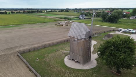 Alte-Hölzerne-Windmühle-Auf-Einer-Wiese,-Die-An-Einem-Bewölkten-Tag-Aus-Der-Luft-Zirkuliert