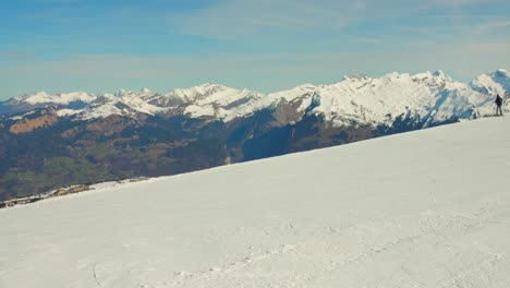 Skier-descending-frosty-slopes-at-Flaine-ski-resort-with-panoramic-mountain-backdrop,-sunny-day