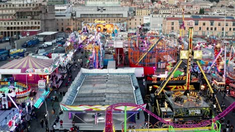 Vista-Aérea-En-Camión-De-Emocionantes-Atracciones-Iluminadas-En-Luna-Park,-Ponte-Parodi