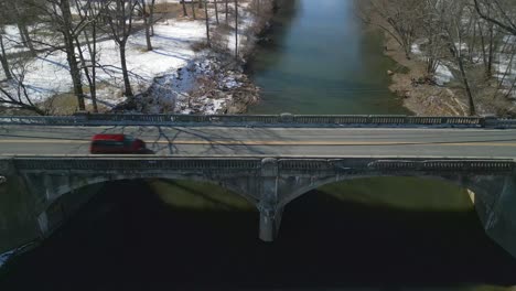 Aerial-drone-footage-of-creek-and-transportation-bridge-over-top