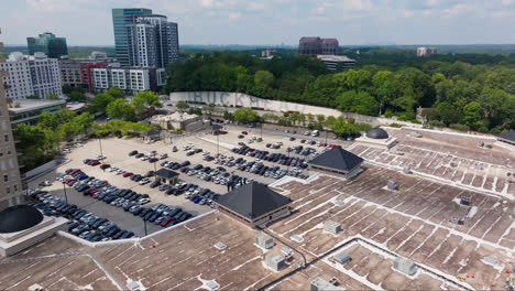 Aerial-flyover-roof-of-buildings-and-many-parking-cars-in-Buckhead-District,-Atlanta