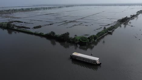 Dos-Tablas-En-Medio-Del-Agua,-Un-Barco-Está-Parado-Tranquilamente-En-La-Orilla-Y-Un-Agua-Está-Llena-De-Gente-Y-En-La-Parte-De-Atrás-Hay-Muchos-Cocoteros-Diferentes