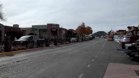 Downtown-Sedona,-Arizona-with-vehicles-and-pedestrians-and-video-panning-right-to-left
