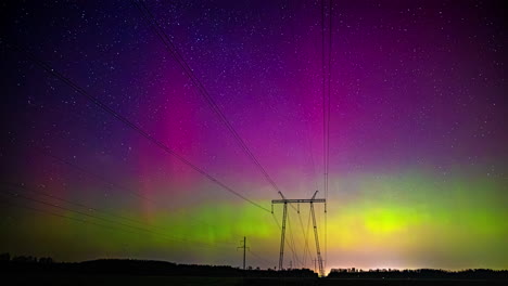 Vibrant-solar-storm-behind-electric-wires-in-a-countryside-landscape--Time-lapse