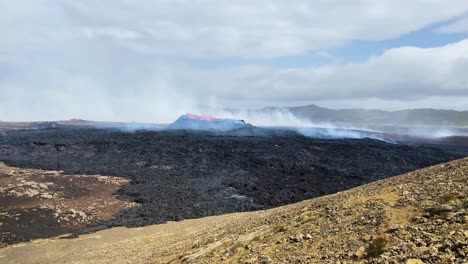 Abgekühlte-Schwarze-Lava-Vor-Dem-Ausbruch-Eines-Glühend-Roten-Lava-Geysirs