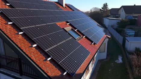 Red-House-Roof-With-Photovoltaic-Panels-In-Sunlight