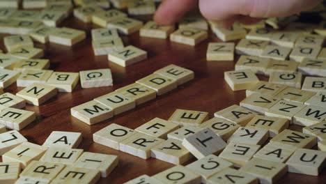 Primer-Plano-De-Enfoque-Estrecho:-Las-Fichas-De-Letras-Forman-Asesinato-De-Palabras-En-El-Juego-De-Scrabble