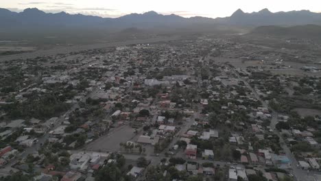 Desert-look-city-below-mountain-valley-at-Loreto-Baja-California-Mexico-Gulf-Famous-Peninsula,-streets-houses-and-neighborhood,-establishing-shot,-Mexican-town