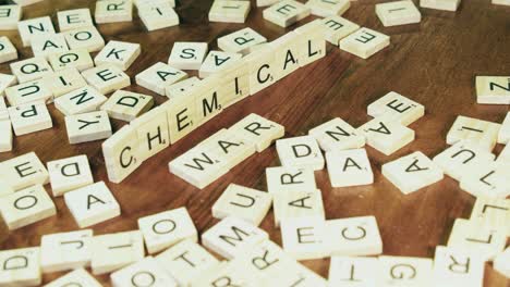 Man's-finger-moves-Scrabble-tiles-on-table-to-make-CHEMICAL-WARFARE