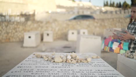 a-jewish-boy-approching-a-grave-with-a-box-full-of-papers-in-har-har-HaMenuchot-greave-yard-in-isreal