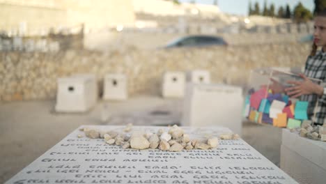 Un-Niño-Judío-Acercándose-A-Una-Tumba-Con-Una-Caja-Llena-De-Papeles-En-El-Patio-De-Greaves-De-Har-Har-Hamenuchot-En-Israel.