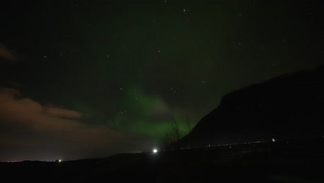 Flackernde-Aurora-Borealis-Mit-Fahrenden-Autos-Auf-Der-Ionenstraße-In-Der-Nacht-Auf-Der-Insel-Island