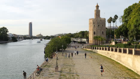 Gente-Alrededor,-Torre-Del-Oro-Junto-Al-Río-Guadalquivir,-Sevilla,-España