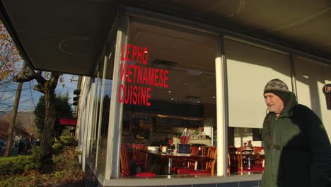 Ein-Mann-Geht-An-Einem-Vietnamesischen-Restaurant-In-East-Vancouver,-British-Columbia,-Kanada-Vorbei---Nahaufnahme