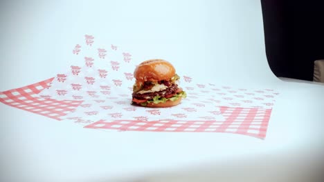 4K-Kinoaufnahmen-Von-Einem-Köstlichen-Hausgemachten-Burger,-Der-In-Einem-Restaurant-Auf-Weißem-Hintergrund-Mit-Studiobeleuchtung-Präsentiert-Wird