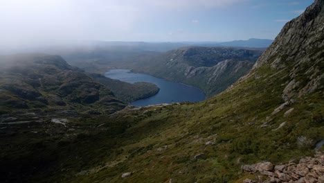 Wide-angle-shot-of-range-of-hills-surrounding-lake-during-daytime