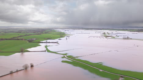 Aerial-pullback-view-of-flooded-English-landscape-around-River-Tone,-Somerset