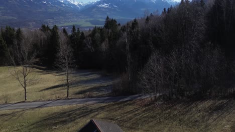 Drones-Vuelan-Sobre-Una-Pequeña-Cabaña-En-Las-Montañas-Con-Vista-Aérea-Sobre-El-Paisaje-Urbano-Y-Las-Montañas-Nevadas-En-Austria
