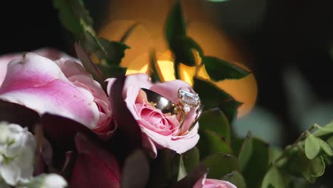 Bridal-bouquet-designed-with-pink-lily-flower-has-golden-wedding-rings-between-its-petals