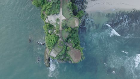 Top-down-drone-shot-over-tropical-Balangan-Beach-peninsula-in-Uluwatu-Bali-Indonesia-with-crashing-waves-and-turquoise-water