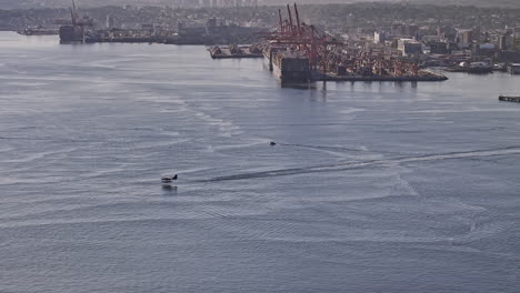 Vancouver-Bc-Canada-Drone-V79-Aéreo-Sobrevolando-El-Puerto-Capturando-El-Despegue-épico-Del-Hidroavión-En-El-Agua-Hacia-El-Cielo-Contra-El-área-Industrial-Y-La-Montaña-Norte---Filmado-Con-Mavic-3-Pro-Cine---Julio-De-2023