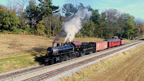 Una-Vista-Aérea-De-Un-Antiguo-Tren-De-Pasajeros-De-Carga-A-Vapor-Que-Soplaba-Humo-Mientras-Se-Detenía-En-Un-Día-De-Otoño.