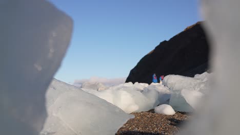 Tourists-Visiting-Glacier-Area-Location,-Walking-Between-Pieces-of-Ice-on-Sunny-Day