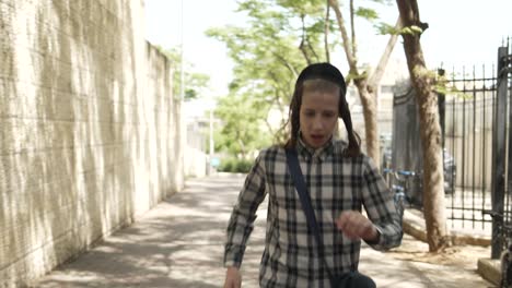 jewish-kid-runing-in-the-street-slow-motion-front-veiw