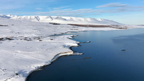 Luftaufnahme-Einer-Wunderschönen-Winterberge-Und-Küste-Islands-An-Einem-Sonnigen-Tag