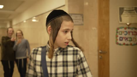 a-slow-motion-video-of-a-jewish-12-year-old-boy-entering-a-hallway-in-school-and-getting-laughed-at