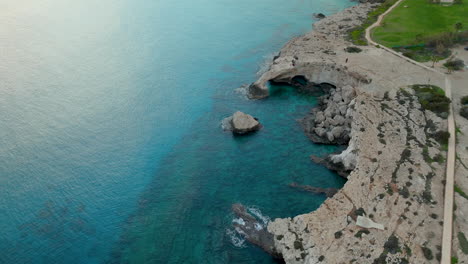 Raue-Schönheit-Von-Zypern,-Dieses-Bild-Zeigt-Einen-Natürlichen-Felsbogen-In-Der-Nähe-Von-Ayia-Napa,-Azurblaues-Wasser-Des-Mittelmeers-Trifft-Auf-Die-Felsige-Küste,-Hervorgehoben-Durch-Das-Sanfte-Licht-Einer-Untergehenden-Oder-Aufgehenden-Sonne