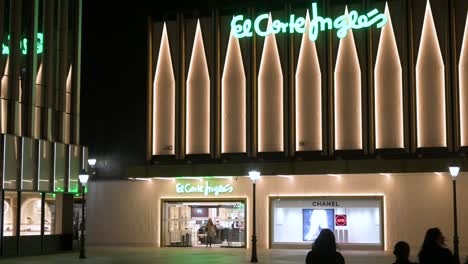 Shoppers-arrive-at-the-Spanish-biggest-department-store-company,-El-Corte-Ingles,-building-during-nighttime-in-Spain