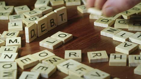 Close-up:-Words-DEBT-and-LOAN-are-spelled-using-Scrabble-letter-tiles