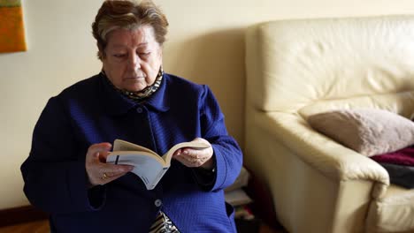 Grandmother-reading-a-book-with-difficulty-turning-pages-due-to-Parkinson's-in-her-hand