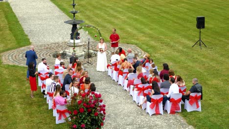 Eine-Weltliche-Trauung-In-Einem-Großen-Garten,-Rot-weißer-Dresscode,-Die-Braut-Wartet-Auf-Ihre-Frau